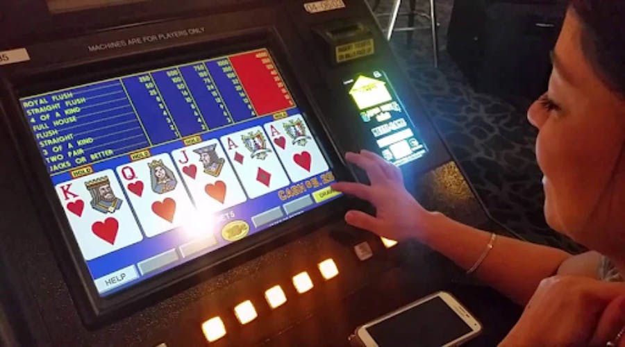 Woman plays a video poker at a casino